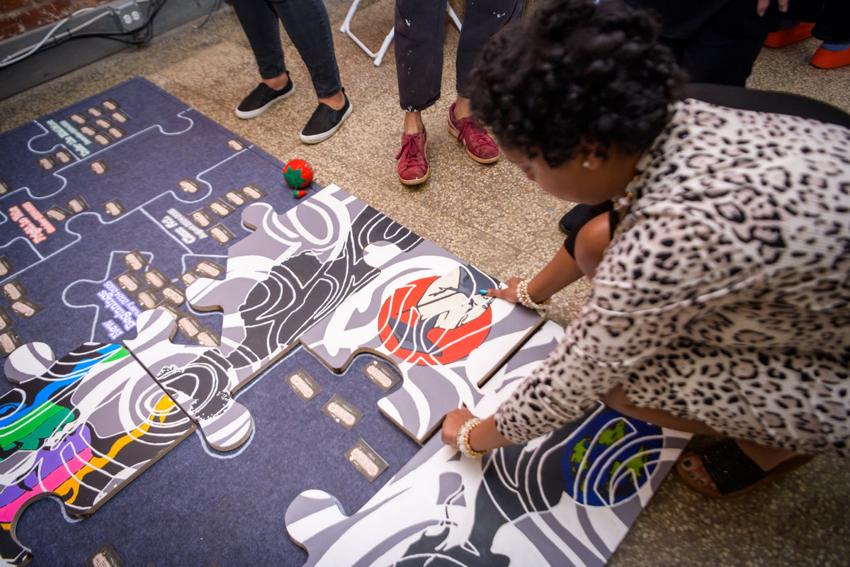 A participant placing a large illustrated puzzle piece during a Wildcard experience